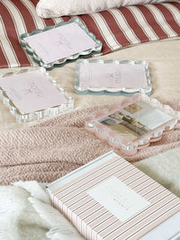 norsu Studio scalloped magnetic photo frames in blush and clear acrylic with modern gallery-style design on soft textile background