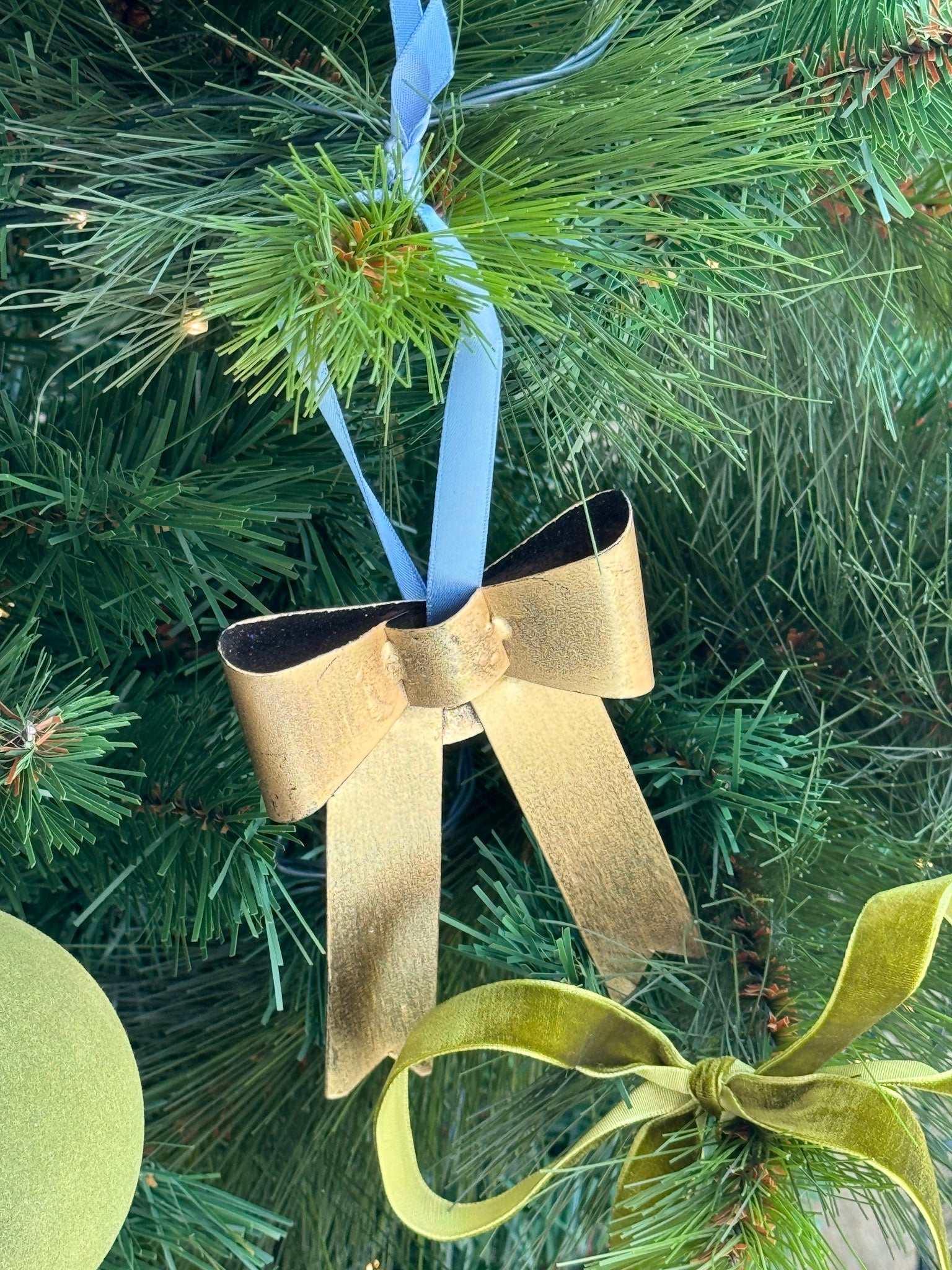 norsu STUDIO handcrafted gold bow ornament with nude satin ribbon hanging on Christmas tree