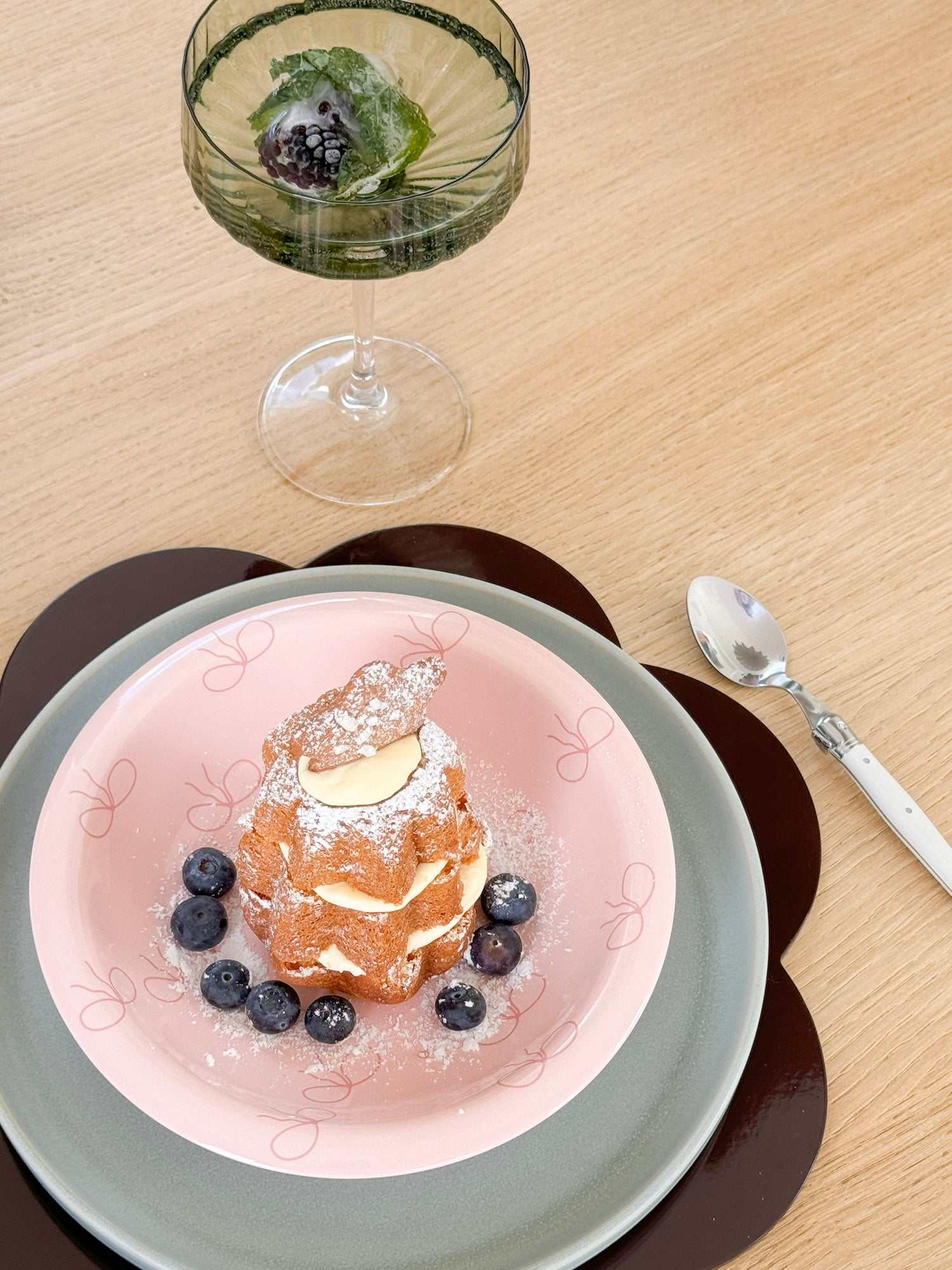 norsu Studio Bow Bowl in pink with deep pink bow pattern serving dessert with blueberries on layered plates