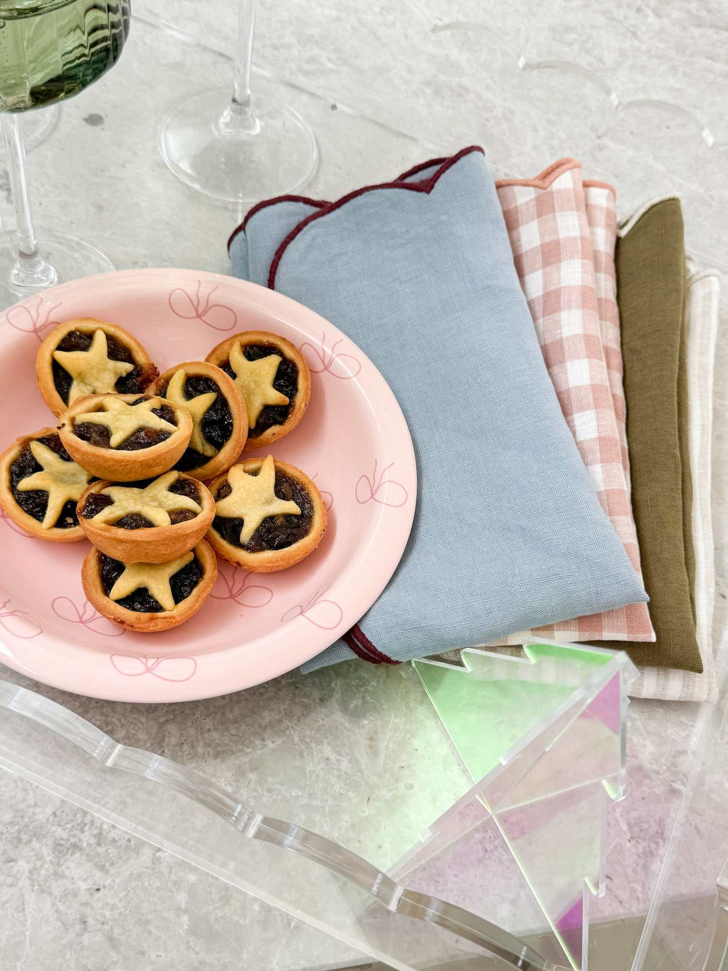 norsu Studio Bow Bowl in pink with deep pink bow holding star-shaped tartlets on a table with folded cloth napkins