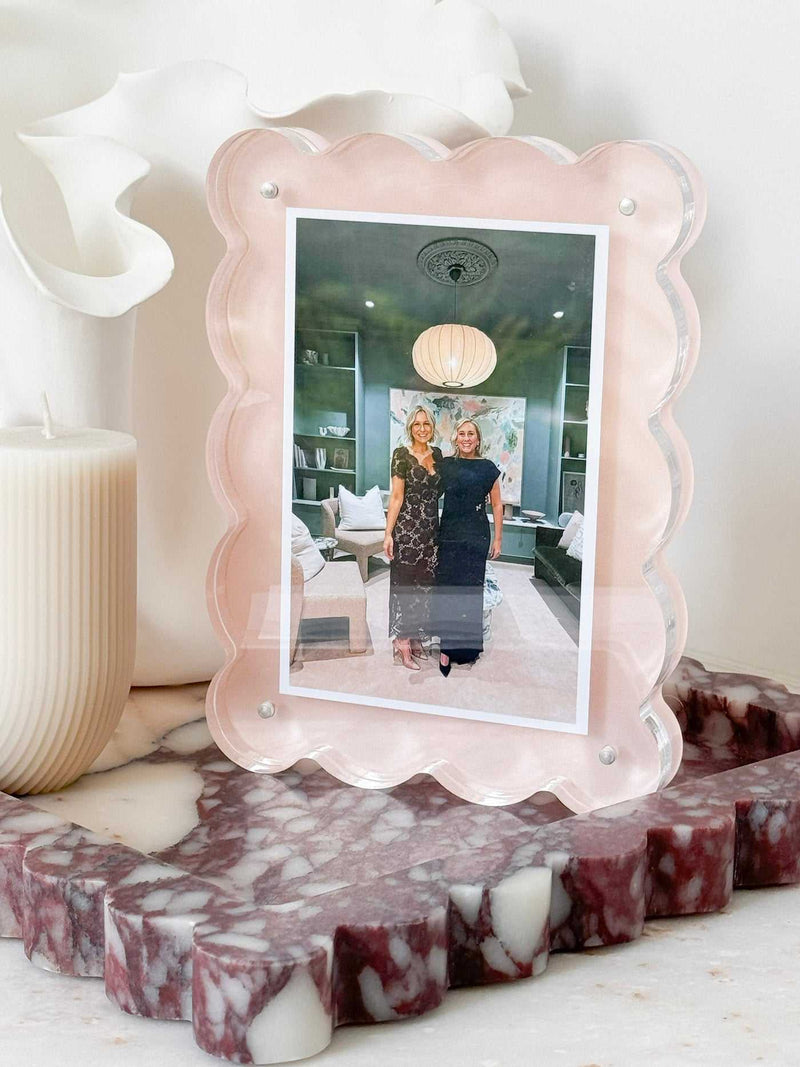 norsu Studio Scalloped Magnetic Photo Frame in blush with scalloped edges and 2.5 cm depth displaying a portrait photo on a marble surface next to a white candle