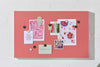Berry colored magnetic story board with notes and photos attached using round magnets on a white wall