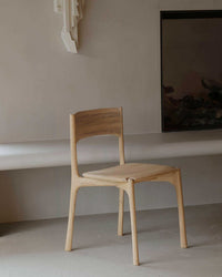 Ethnicraft PI Dining Chair in natural oak with sleek, curved wooden design and polished finish.