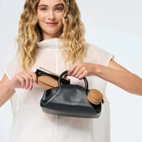 Fox and Leo Eye Catcher Bag Charm in tan leather with gold hardware attached to black handbag