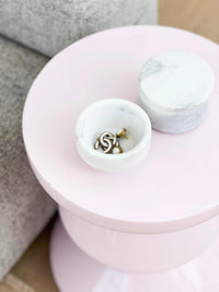 Stackable marble jewellery organiser with removable lid holding rings on pink table