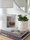norsu Studio Scalloped Magnetic Photo Frame with blue scalloped acrylic design on books next to plant and lamp