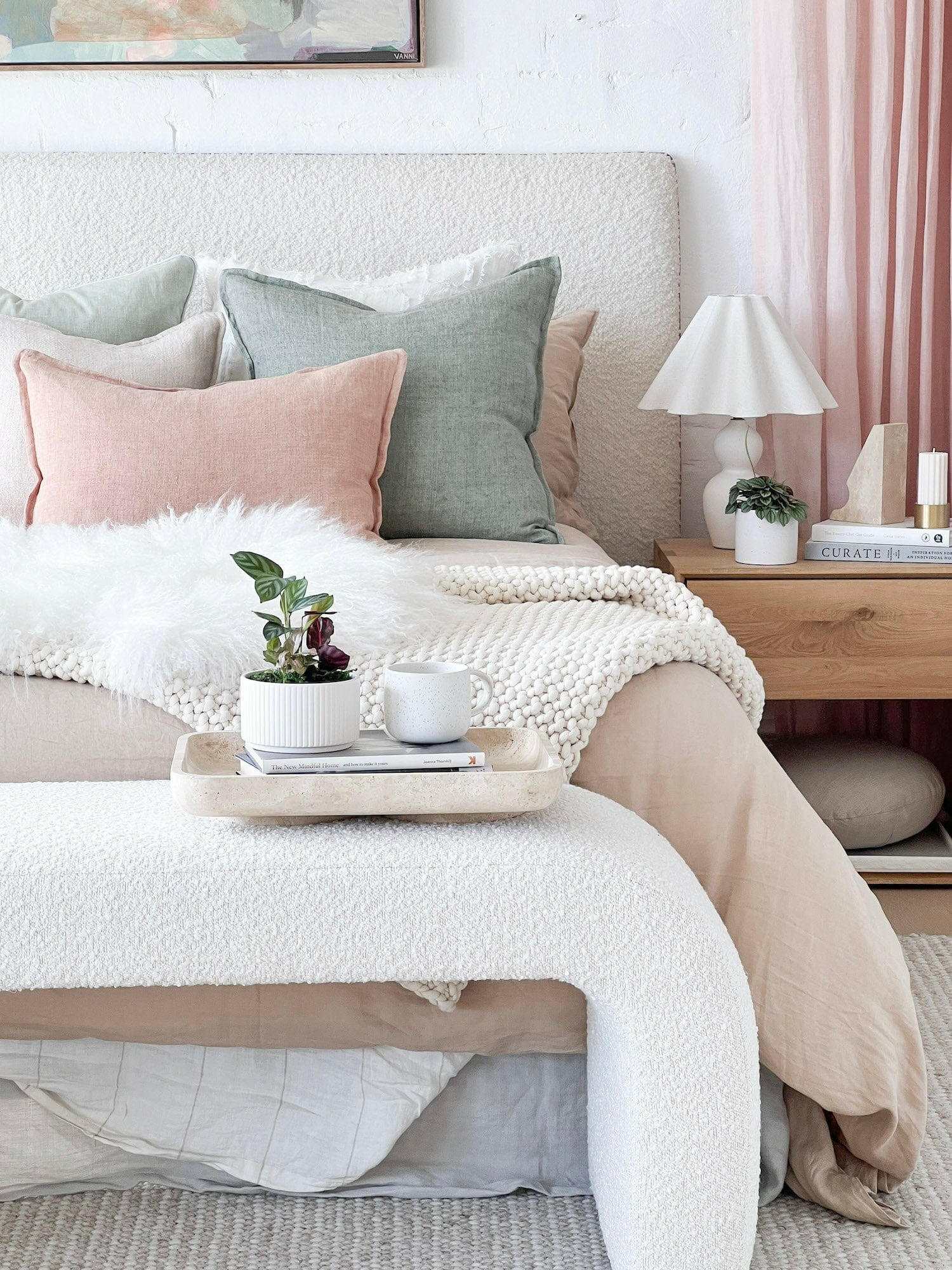 CoTheory Travertine Footed Letter Tray in beige on bed with textured bedding and pastel pillows