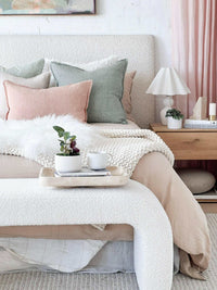 CoTheory Travertine Footed Letter Tray in beige on bed with textured bedding and pastel pillows