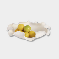 Lottie Decorative Bowl white ceramic with ruffled edges holding lemons and lime on white background