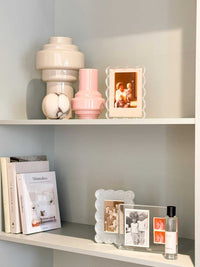 norsu Studio Scalloped Magnetic Photo Frame with acrylic scalloped edges displaying photos on a shelf with decorative vases and books