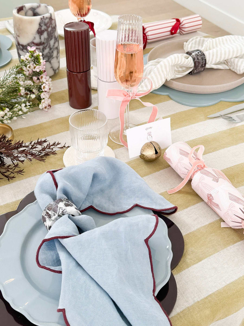 Blue norsu Studio Linen scallop-edged napkin with deep burgundy edge on a table setting