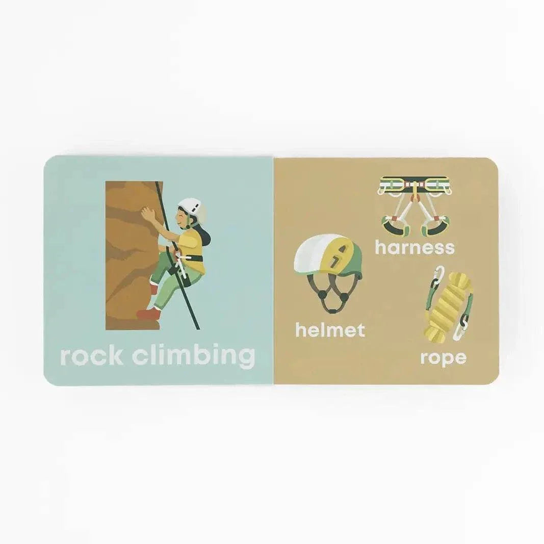 Open children's board book showing illustrations of a child rock climbing with helmet, harness, and rope labeled Mountain Baby book