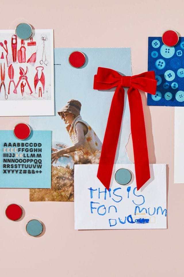 Mustard Made The Buttons red and blue round magnets holding photos and notes on a wall