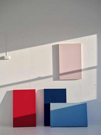 Minimalist room with mustard made lockers in red, navy, and blue alongside a pink powder-coated Storyboard on the wall.