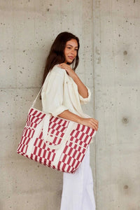 Burgundy and peony check insulated Cooler Base tote bag with adjustable strap and front pockets carried by woman