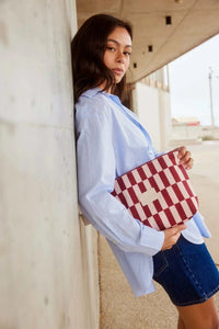 Woman holding Base Supply Wet Base Large pouch in burgundy and peony check pattern outdoors