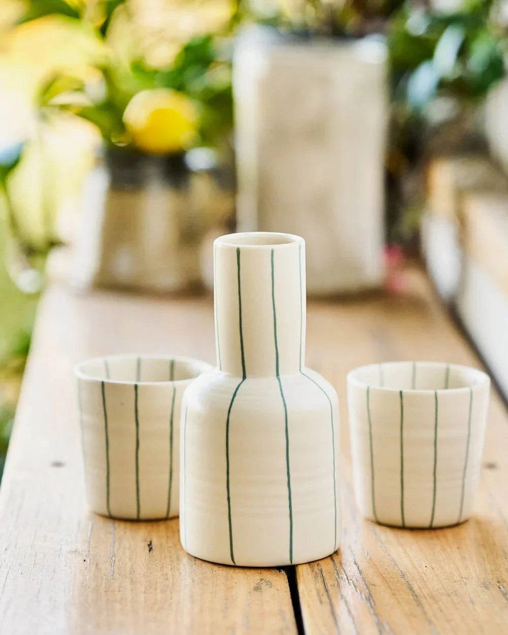 Robert Gordon Coastal Junction cream stoneware carafe set with green stripes and two matching cups on wooden table