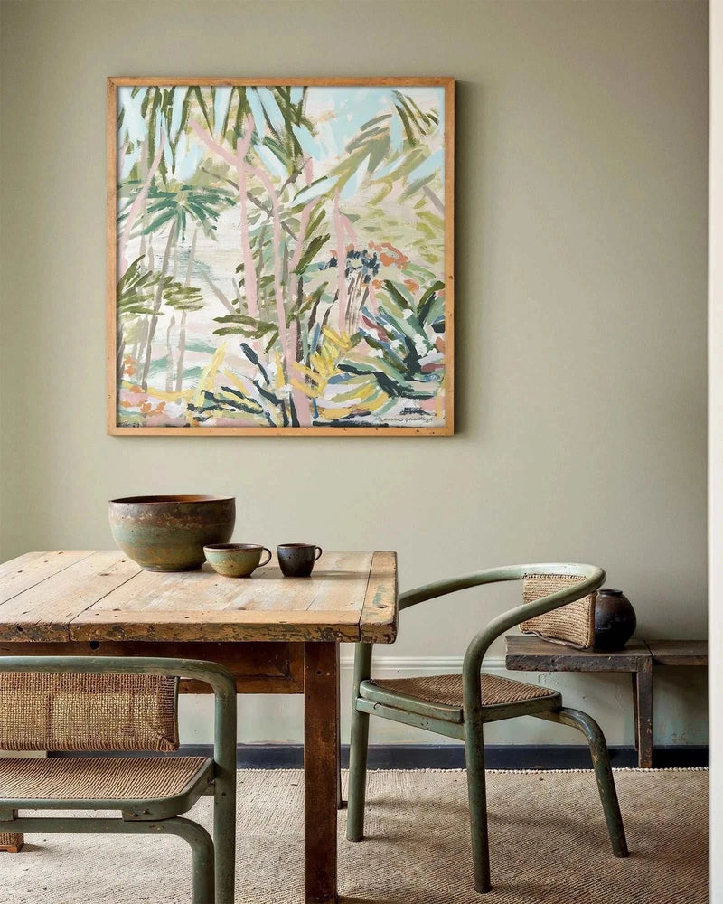 Limited edition fine art canvas print "Catamaran County Pt 1" by Marcia Priestley in floating oak frame above rustic wooden dining table with ceramic bowls and woven chairs.