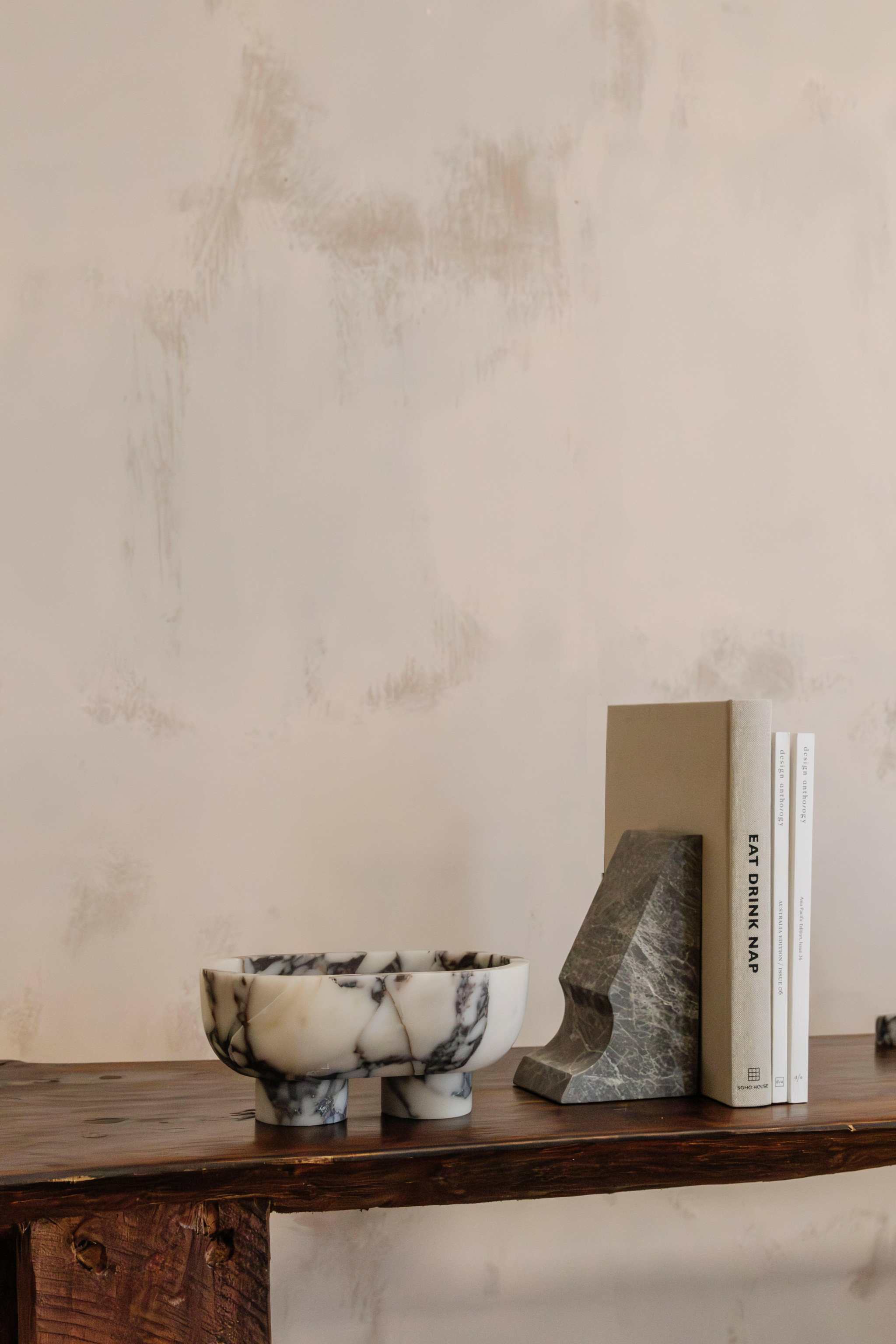 CoTheory marble footed oval tray in Viola marble on wooden surface with books and stone bookend