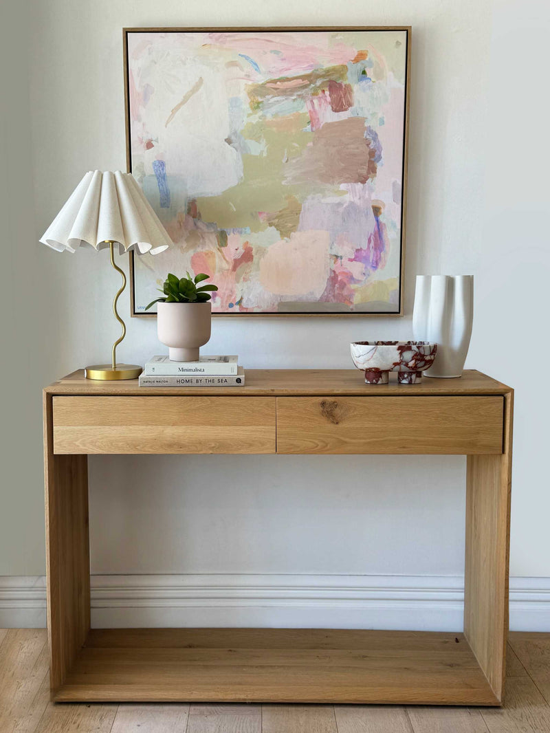 Decoratively styled console table with plants, artwork, and elegant objects for interior refresh