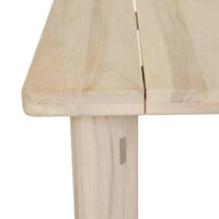 Close-up of aged teak GlobeWest Montana Raft Dining Table corner with slatted top and solid leg