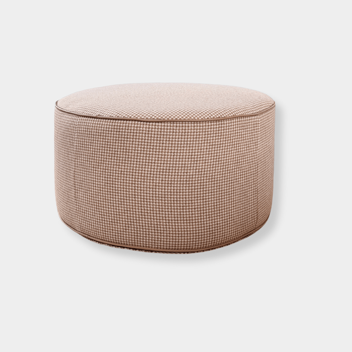 Round ottoman from Forma Collection with natural houndstooth fabric and blush leather piping, lightweight and soft with foam coil filling