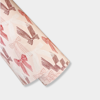 Roll of norsu Studio Christmas Wrapping Paper with pink bow design on pink background, 50 metre jumbo roll