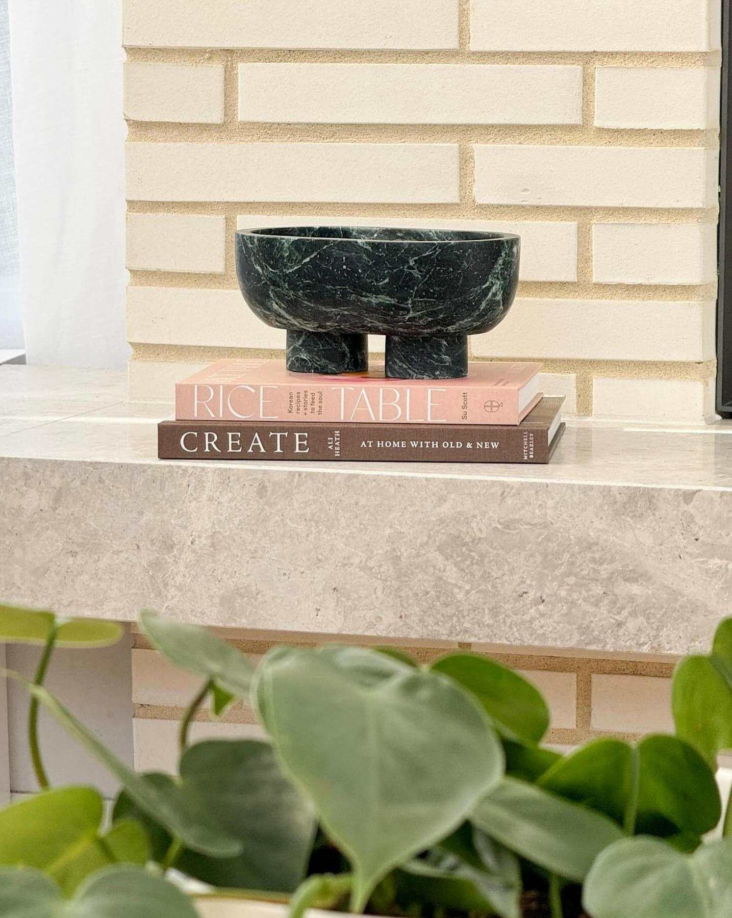 Rice Table by Su Scott cookbook featuring Korean Fried Chicken recipes displayed on a marble surface with a decorative black bowl and green plant.