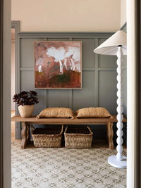 Marcia Priestley Limited Edition Fine Art Canvas Print Dadirri 1 hanging in a stylish room with wooden bench, woven baskets, and white floor lamp.