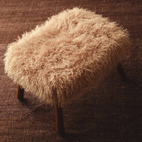 Frankie faux fur ottoman styled on a rug