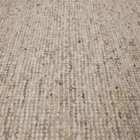 Close-up of GlobeWest Tepih Maren hand-woven wool rug in stone color showing texture and subtle color variations