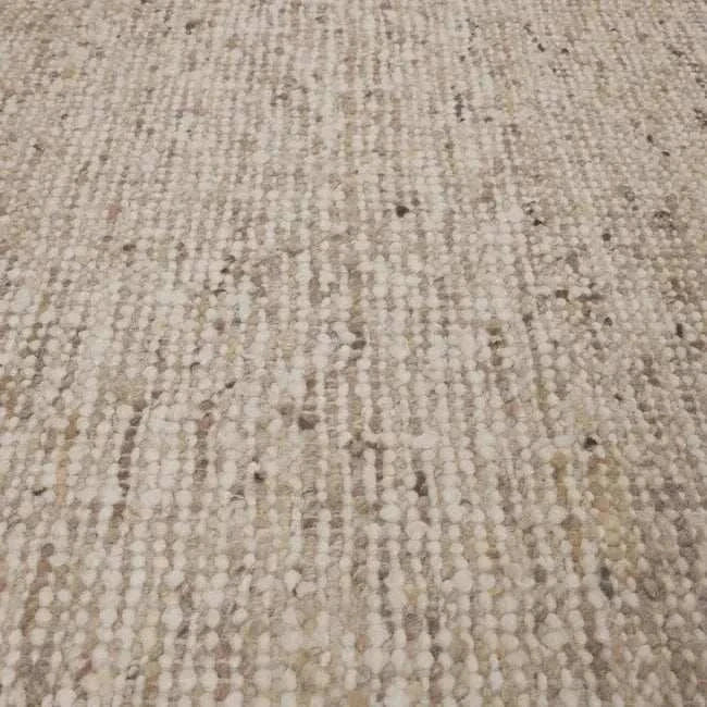 Close-up of GlobeWest Tepih Maren hand-woven wool rug in stone color showing texture and subtle color variations