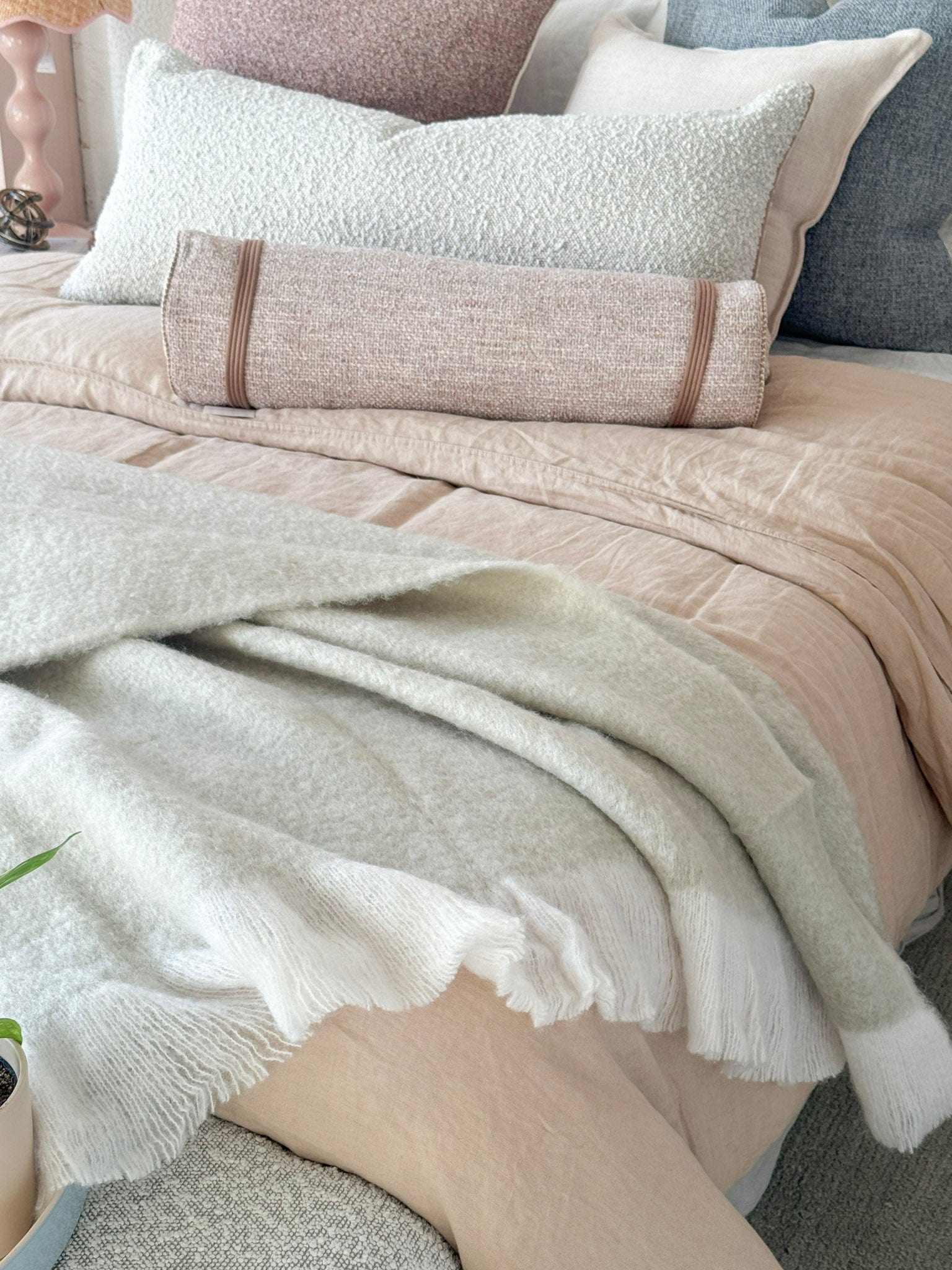Baya Sorrento Throw off white soft brushed wool blend with feathered fringe on bed
