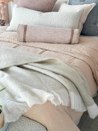 Baya Sorrento Throw off white soft brushed wool blend with feathered fringe on bed