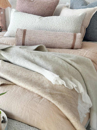 Baya Sorrento Throw off white soft brushed wool blend with feathered fringe on beige bedding