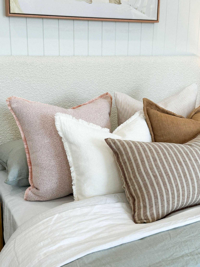 Ivory norsu Cabin Bedhead king size with textured fabric and self-piped trim behind bed with assorted neutral pillows