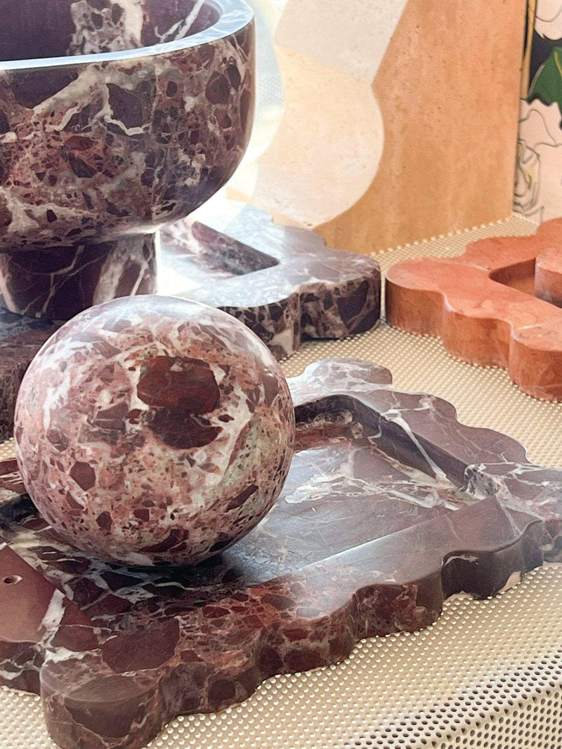 CoTheory Orbit Table Sculpture Rosso Levanto marble sphere on matching marble tray with decorative items