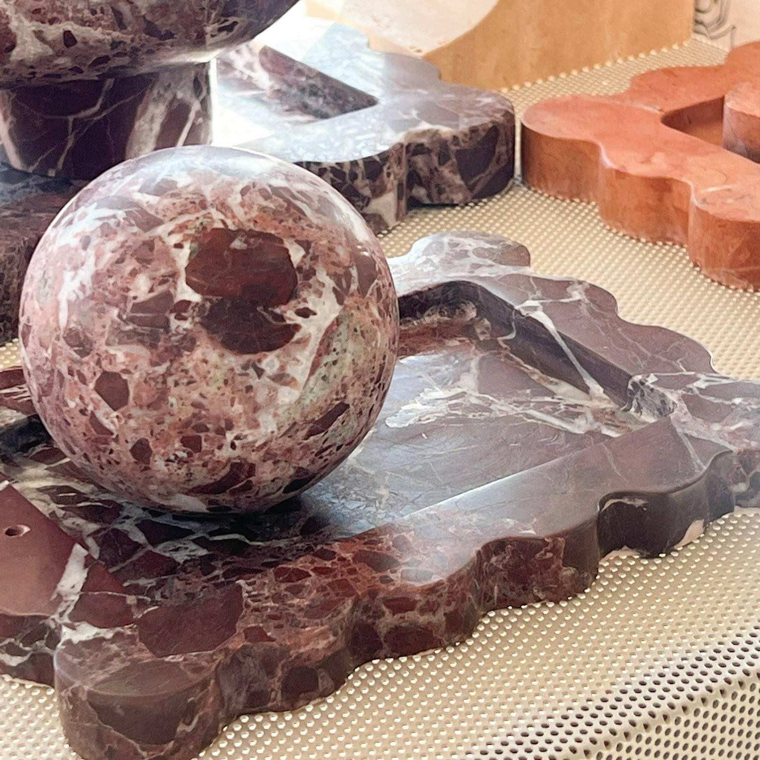 CoTheory Rosso Levanto marble scalloped tray and spherical incense holder in dark red with natural stone patterns