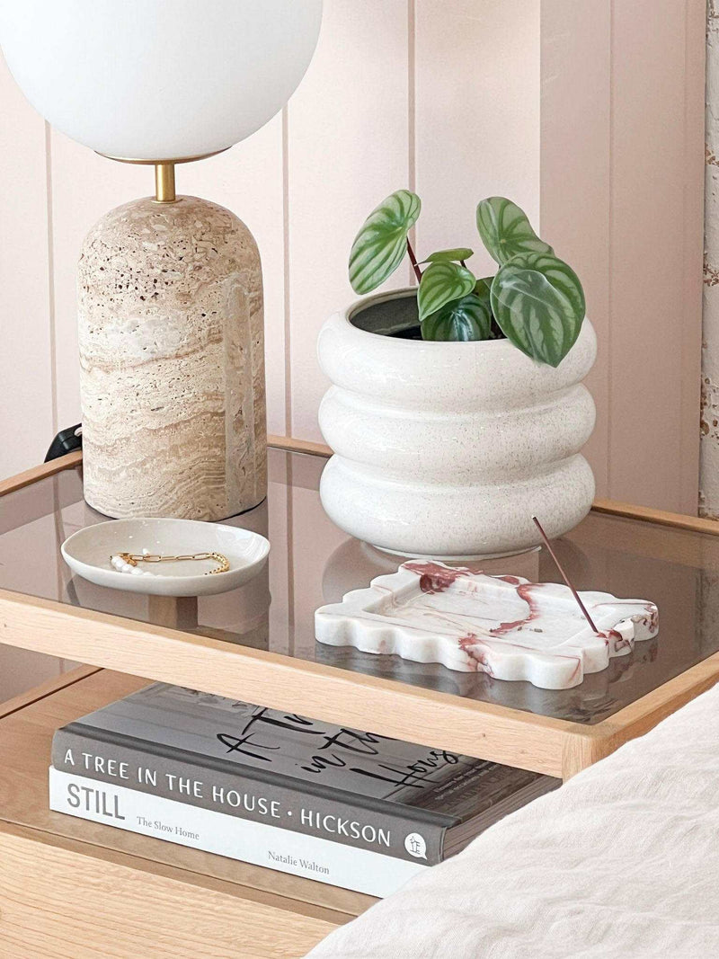 CoTheory small scalloped brown Calacatta marble tray and incense holder on glass table with plant and lamp