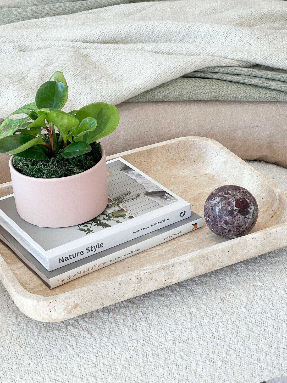 CoTheory Orbit Table Sculpture Rosso Levanto marble sphere on beige tray with books and potted plant