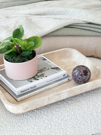 CoTheory Orbit Table Sculpture Rosso Levanto marble sphere on beige tray with books and potted plant