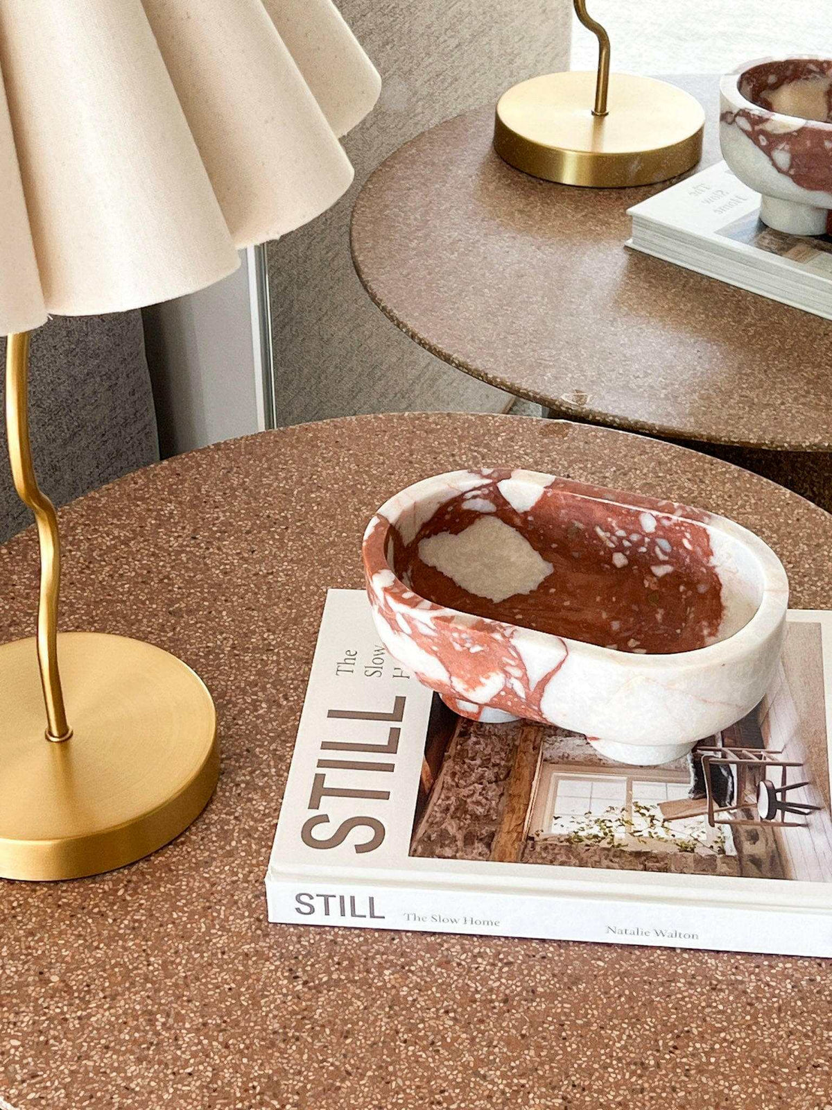 CoTheory Marble Footed Oval Tray in Brown Calacatta on table with books and lamp