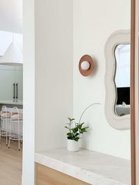 norsu x Robert Gordon dusty rose ceramic dish wall sconce with LED globe on white wall in modern interior