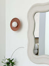 norsu x Robert Gordon dusty rose ceramic dish wall sconce with LED globe next to decorative mirror