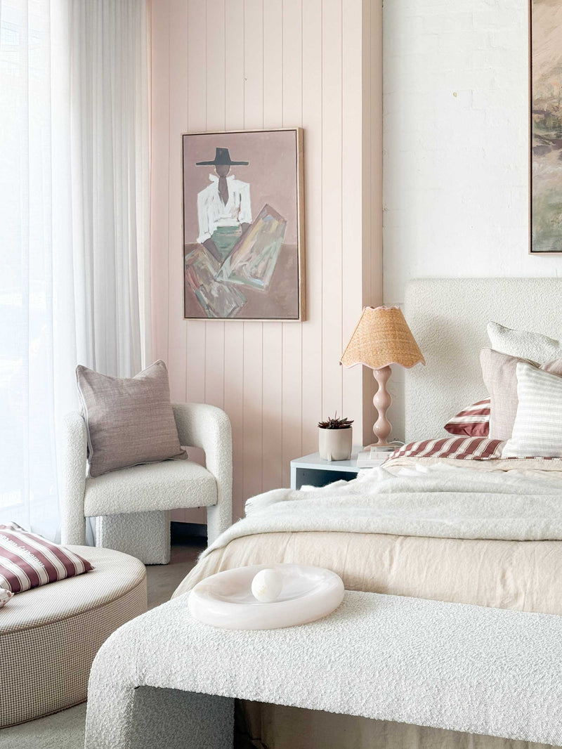 Oak framed Marcia Priestley 'Chaps Rosata' signed canvas print hanging in a soft neutral bedroom interior