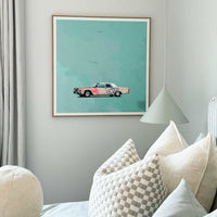 Greg Mount fine art print titled "You Can't Stop The Spring" featuring a vintage car with graffiti on a teal background, framed and displayed in a modern living room setting