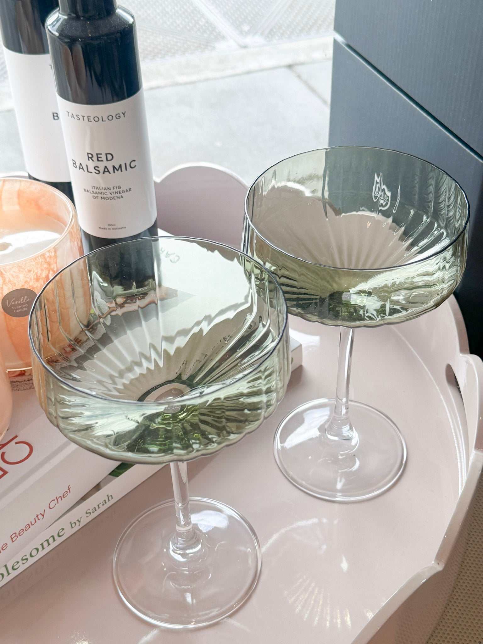 Pair of Levi Ribbed Coupe Glasses in soft green tint with elegant ribbed texture on a tray