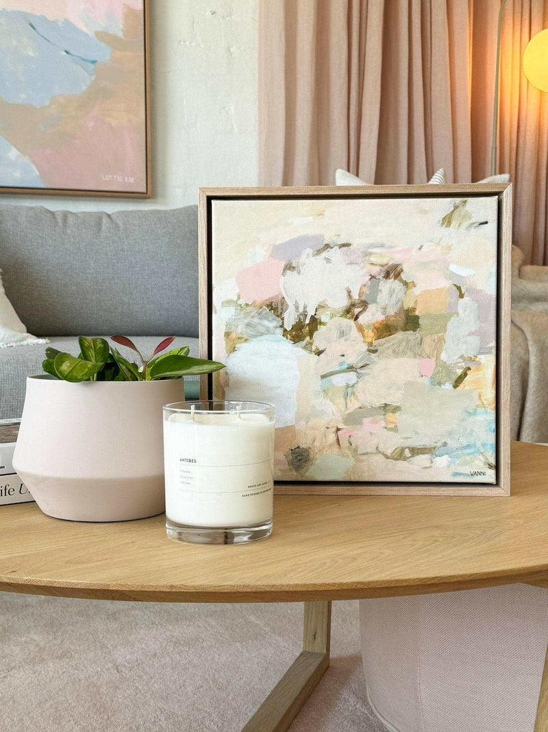 Oak framed Dancing Sunshine limited edition abstract fine art canvas print on wooden table with candle and plant in modern living room