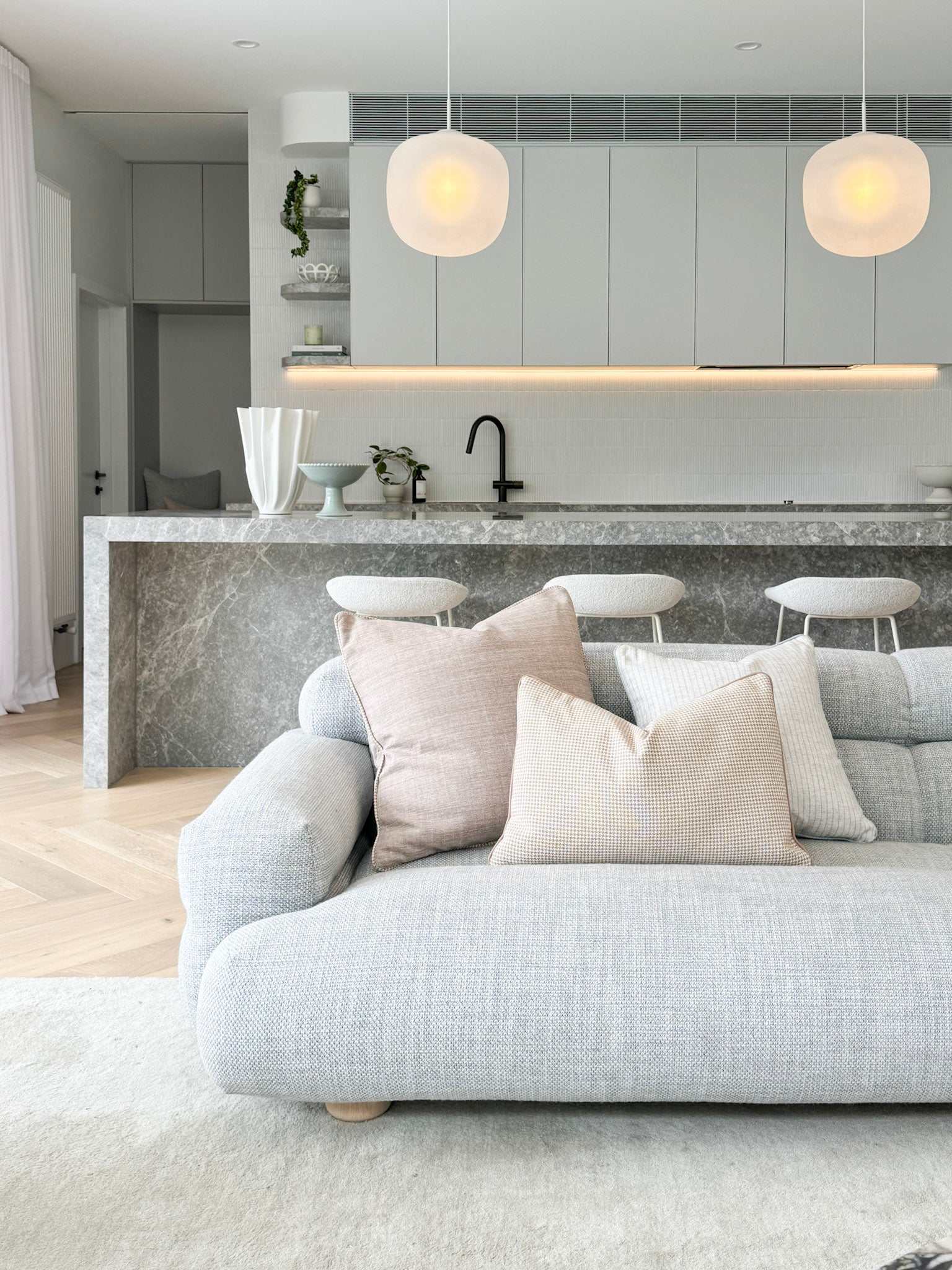 norsu Studio Forma Collection Eden Cushion honey houndstooth on modern grey sofa in minimalist living room