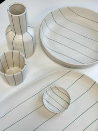Coastal Junction collection ceramic dishware set with cream base and green stripes including condiment bowl, plates, and vase